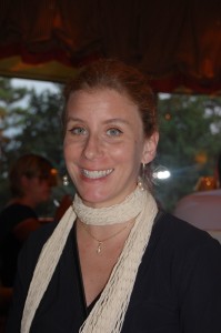 Smiling woman wearing a white scarf indoors.